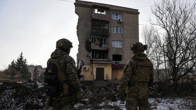 Ukraińscy żołnierze przed zniszczonym domem w Bachmucie