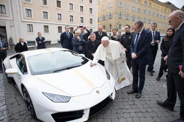 Papież Franciszek składa podpis na masce lamborghini 