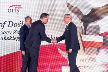 Krzysztow Dośla (z prawej) oraz&nbsp;wręczający nagrodę: Marcin Horała i&nbsp;Adam Pawlik, prezes Polregio