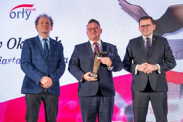 Jarosław Okoczuk (pośrodku)  oraz&nbsp;wręczający nagrodę: Wojewoda małopolski Łukasz Kmita (z prawej) i&nbsp;prof. Włodzimierz Bernacki Sekretarz Stanu, Pełnomocnik Rządu ds. monitorowania wdrażania reformy szkolnictwa wyższego i&nbsp;nauki