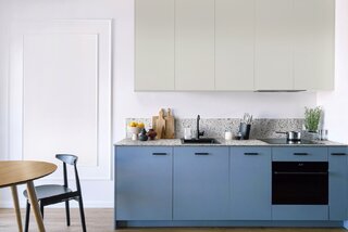 Zadziorny styl kuchni tworzą niebieskie szafki (Błękit Północny), a wyrafinowania dodaje blat z dekorem lastriko (Terrazzo Colore). Subtelny odcień (Szary Neutralny) górnych szafek sprawia, ze zdają się znikać na tle ściany