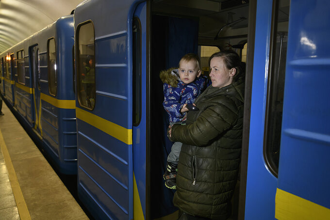 Kobieta z dzieckiem w wagonie kijowskiego metra