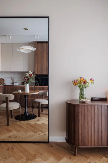 Ciepła kolorystyka, zabudowy na wymiar i inspiracje stylem mid-century modern tworzą wnętrze, które łączy ponadczasową estetykę z codzienną funkcjonalnością 