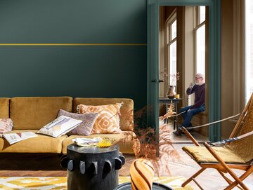Kolor roku 2025 &bdquo;Hello Yellow&rdquo; pod&nbsp;postacią cieniutkiej linii przecinającej ciemnozieloną ścianę. Zauważcie, że&nbsp;na kolor ściany pomalowano także drzwi
