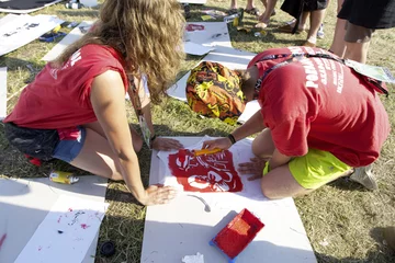 Uczestnicy Przystanku Woodstock 2012 malują na koszulkach symbole związane z Powstaniem Warszawskim, fot. PAP/Lech Muszyński