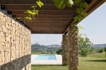 Drewniana pergola, trawertyn i&nbsp;gliniane tynki tworzą architekturę podporządkowaną światłu, widokom i&nbsp;codziennemu życiu, projekt 	Sebastian Nagy