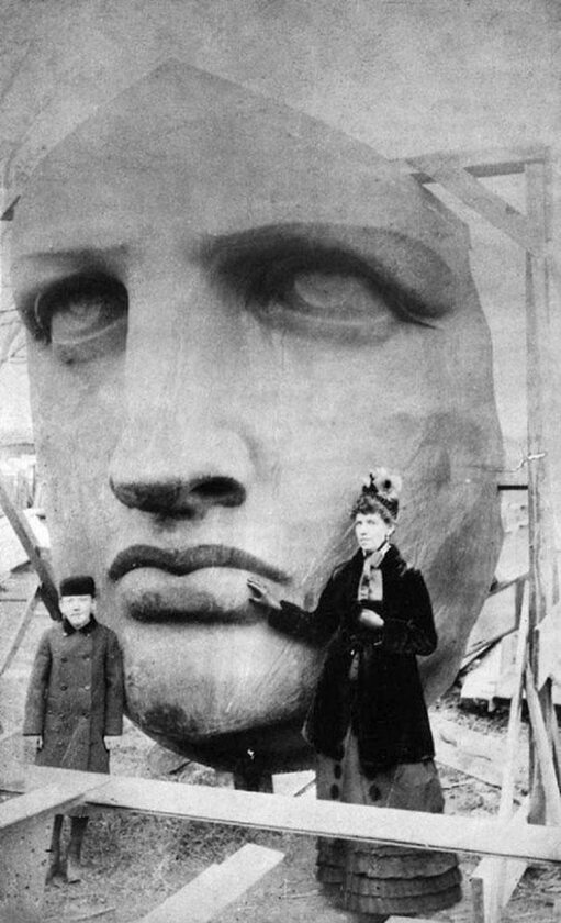 Ludzie pozujący na tle Statuy Wolności tuż po jej przybyciu do USA (1886 r.), fot. epicdash.com