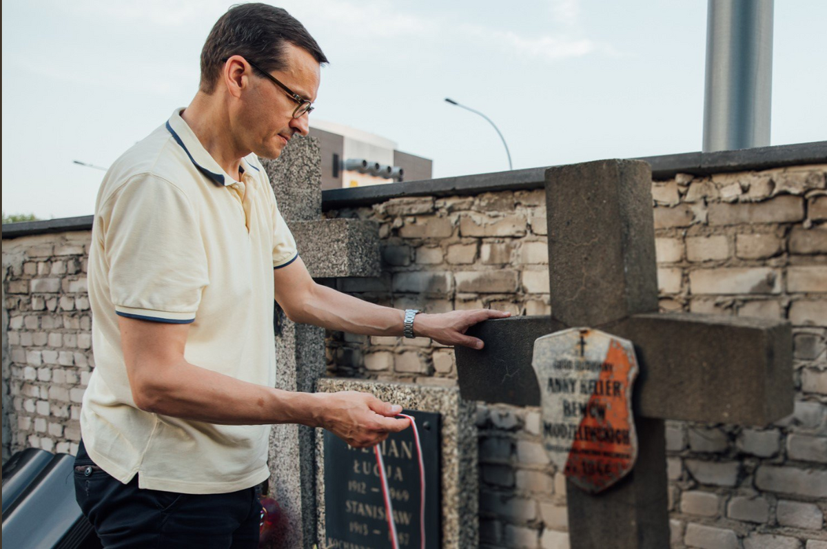 Mateusz Morawiecki porządkujący groby powstańców 