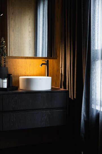 Projekt pracowni masz.design pokazuje, że ciemna kolorystyka, naturalne drewno i światło mogą stworzyć wnętrze pełne spokoju, elegancji i ponadczasowego charakteru 