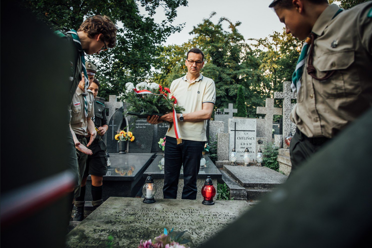 Mateusz Morawiecki porządkujący groby powstańców 