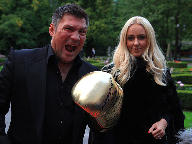 Były bokser Dariusz Michalczewski wraz z żoną prezentuję złotą rękawicę - prezent dla jubilata (fot. PAP/Piotr Wittman)