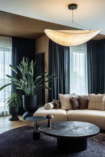 Projekt pracowni masz.design pokazuje, że ciemna kolorystyka, naturalne drewno i światło mogą stworzyć wnętrze pełne spokoju, elegancji i ponadczasowego charakteru 
