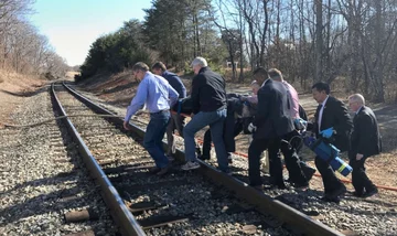 Pasażerowie pociągu pomagający rannemu kierowcy uderzonej ciężarówki 