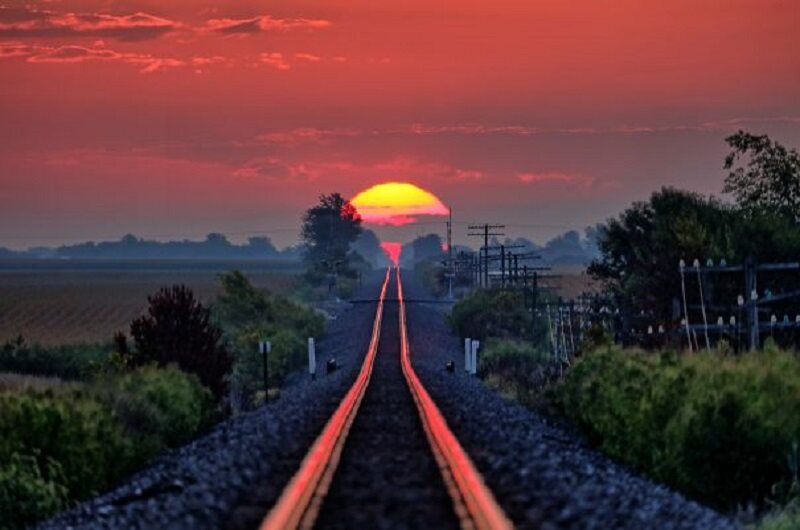 Zachód słońca odbijający się od torów kolejowych 