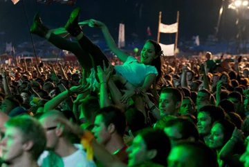 Uczestnicy festiwalu bawią się pod sceną fot. PAP/Lech Muszyński