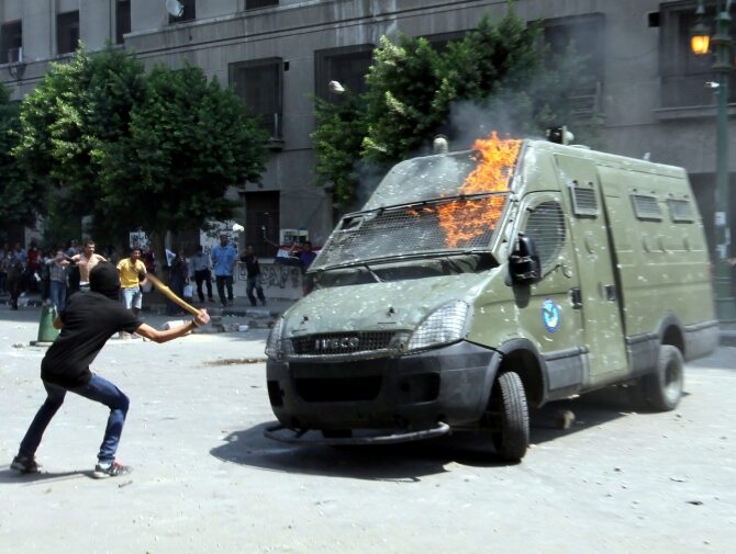 Uczestnicy protestów w Kairze atakują samochód policyjny (fot. PAP/EPA/KHALED ELFIQI)