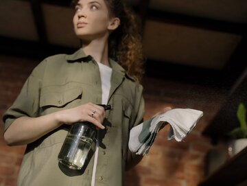 Woman in&nbsp;Green Button Up Shirt Holding Clear Glass Bottle