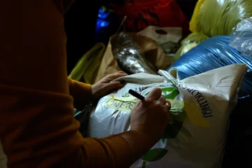 Cały wolny czas na segregowanie paczek Jedna z mieszkanek podpisuje kolejny worek z posegregowanymi darami. Najwięcej czasu zajmuje otworzenie paczek i ułożenie rzeczy. Tak, aby się nie pogubić. – Praktycznie cały wolny czas tu spędzamy – mówi mieszkanka.