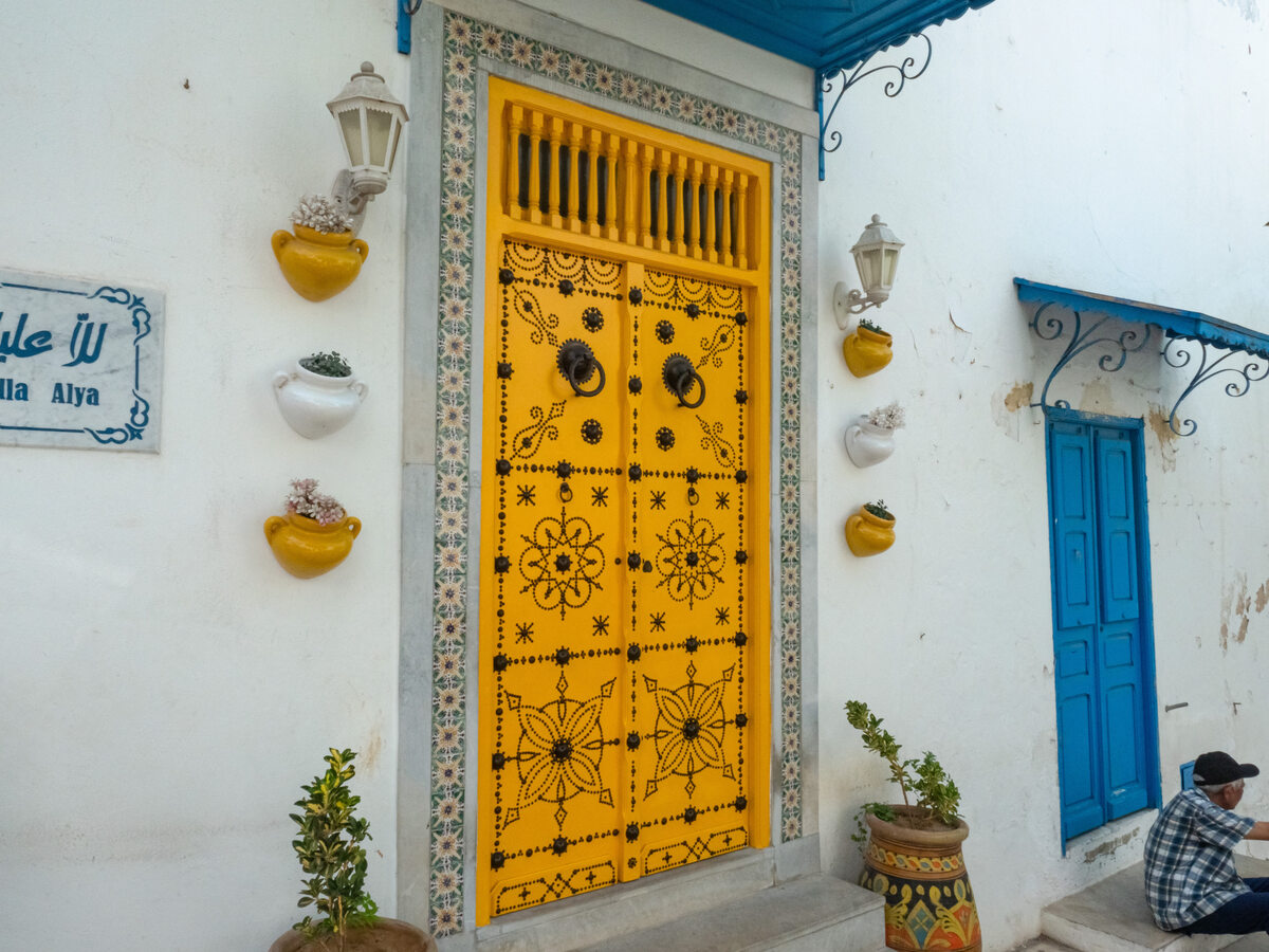Żółte drzwi w Sidi Bou Said W Sidi Bou Said dominują dwie barwy – biel i odcienie niebieskiego. Czasami zdarza się jednak, że mieszkańcy odchodzą od tej tradycji. Na głównej ulicy można znaleźć m.in. drzwi w kolorze żółtym, które wyróżniają się na tle pozostałych wejść.