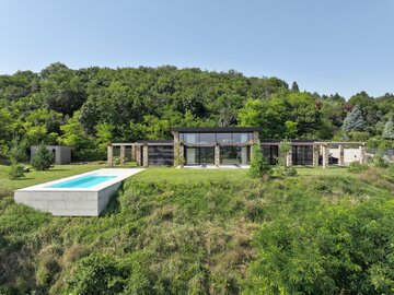 Drewniana pergola, trawertyn i&nbsp;gliniane tynki tworzą architekturę podporządkowaną światłu, widokom i&nbsp;codziennemu życiu, projekt 	Sebastian Nagy
