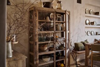 Przeszklona witryna z&nbsp;litego drewna eksponuje naczynia i&nbsp;dodatki, nadając kuchni wrażenie tętniącego życiem wnętrza