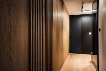 Projekt pracowni masz.design pokazuje, że ciemna kolorystyka, naturalne drewno i światło mogą stworzyć wnętrze pełne spokoju, elegancji i ponadczasowego charakteru 
