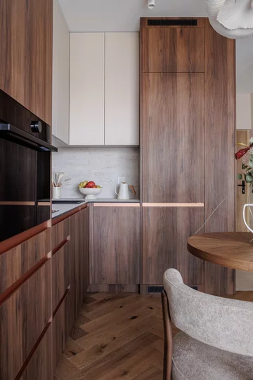 Ciepła kolorystyka, zabudowy na wymiar i inspiracje stylem mid-century modern tworzą wnętrze, które łączy ponadczasową estetykę z codzienną funkcjonalnością 