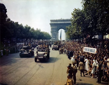 Parada zwycięstwa na Polach Elizejskich po wyzwoleniu Paryża (26 sierpnia 1944 r.) Napis po prawej głosi „Niech żyje de Gaulle”
