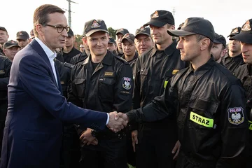 Minister Brudziński i premier Morawiecki witają wracających ze Szwecji strażaków 
