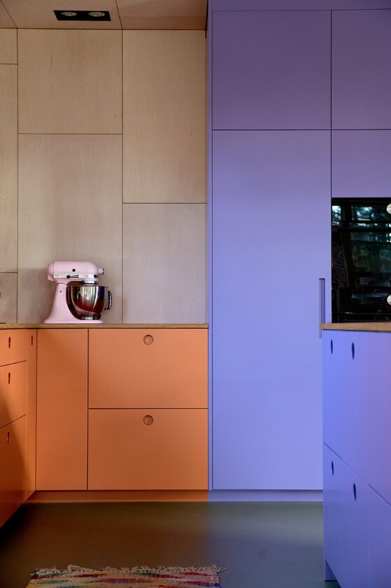 Inspirujące wnętrze z fioletowo-pomarańczową zabudową kuchenną 