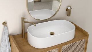 Oszczędne, eleganckie formy – owalna misa nablatowej umywalki, szafka z rattanowym wyplotem oraz bateria Ciriculus w odcieniu szczotkowanego złota. Do tego akcesoriami z linii Smile w tym samym wykończeniu