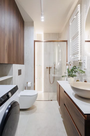 Ciepła kolorystyka, zabudowy na wymiar i inspiracje stylem mid-century modern tworzą wnętrze, które łączy ponadczasową estetykę z codzienną funkcjonalnością 