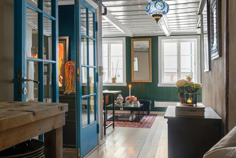 Zielona boazeria, galeria obraz&oacute;w i&nbsp;ciepłe światło &ndash; przykład, jak jeden odważny kolor potrafi całkowicie odmienić salon bez efektu przesady