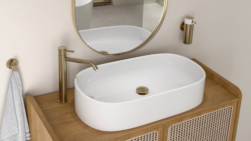 Oszczędne, eleganckie formy – owalna misa nablatowej umywalki, szafka z rattanowym wyplotem oraz bateria Ciriculus w odcieniu szczotkowanego złota. Do tego akcesoriami z linii Smile w tym samym wykończeniu