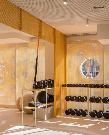 Wnętrza klubu fitness autorstwa Canobardin wyróżniają ażurowe przegrody z perforowanej stali i konsekwentnie zastosowana paleta kolorów 