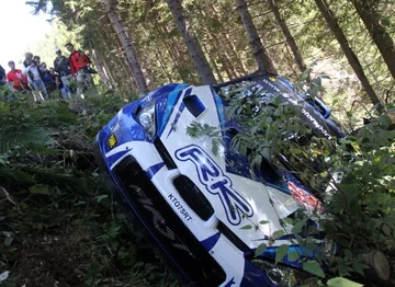 Subaru Impreza WRC polskiej załogi wypadło z zakrętu, zsunęło się ze skarpy i zatrzymało na drzewach (fot. PAP/Grzegorz Momot)