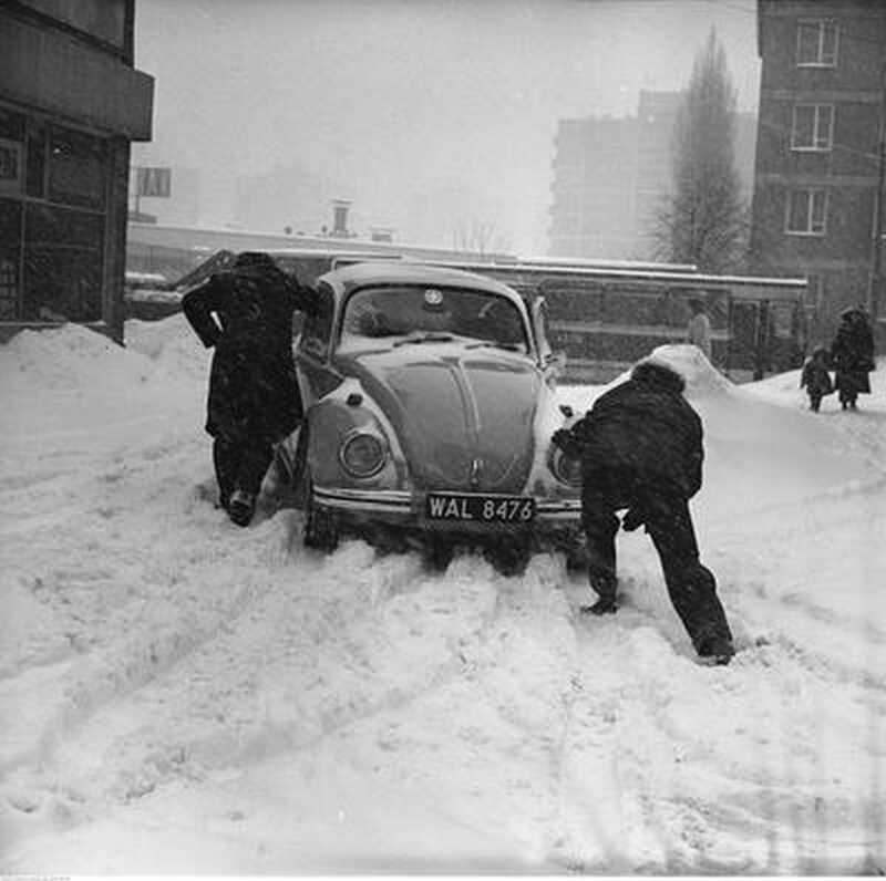 Mężczyźni pchający samochód Volkswagen Garbus 