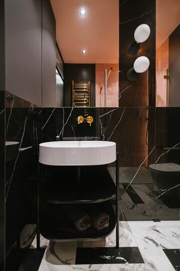 40-metrowy apartament we&nbsp;Wrocławiu zaprojektowany przez pracownię Artefekt łączy głęboką czerń, łososiowy r&oacute;ż i&nbsp;złote detale z&nbsp;klasyczną sztukaterią