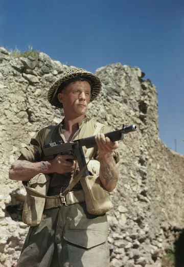 Kapral M. Smith pozuje z pistoletem maszynowym Thompson w San Angelo (Włochy, kwiecień 1944 r.) 