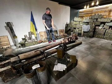 Mężczyzna w muzeum z rosyjską amunicją w Buczi