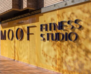 Wnętrza klubu fitness autorstwa Canobardin wyróżniają ażurowe przegrody z perforowanej stali i konsekwentnie zastosowana paleta kolorów 