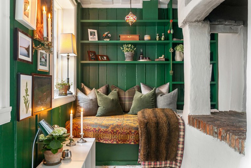 Zielona boazeria, galeria obraz&oacute;w i&nbsp;ciepłe światło &ndash; przykład, jak jeden odważny kolor potrafi całkowicie odmienić salon bez efektu przesady