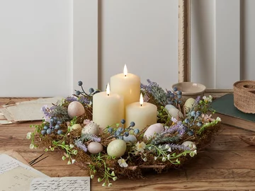 W tym roku na wielkanocnym stole rządzą pastele. Na zdjęciu wieniec z pisankami i świecami, ozdobiony mchem i żywymi roślinami 