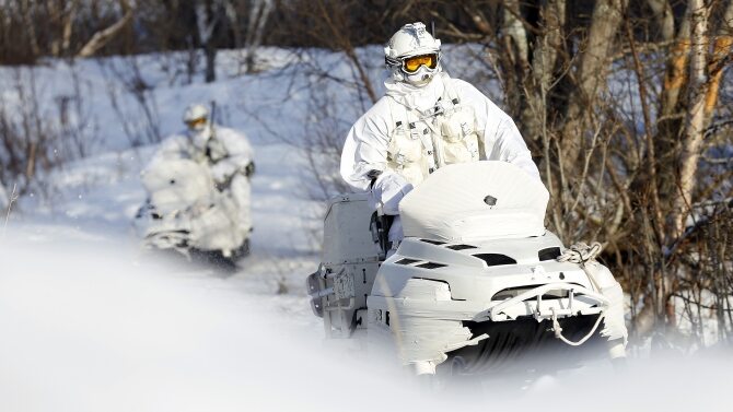 Norwescy żołnierze na specjalnych skuterach śnieżnych w maskującej wszystko bieli
