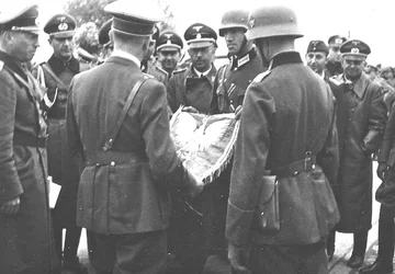 Hitler otrzymuje od niemieckich żołnierzy polskie godło W tle widoczny jest Heinrich Himmler