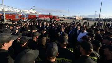 Minister Brudziński i premier Morawiecki witają wracających ze Szwecji strażaków 