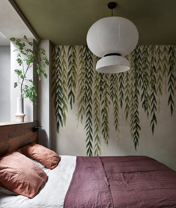 Pomysł na zieloną dekorację sypialni – oliwkowy sufit i zwieszające się z niego gałązki. To tapeta! 