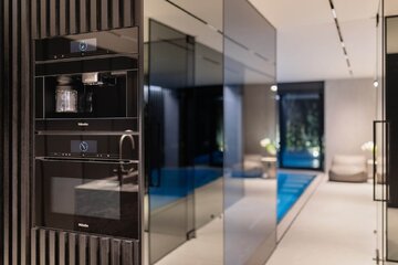 Vibe House w Krakowie – reinterpretacja strefy dziennej z basenem sąsiadującym z salonem i kuchnią 
