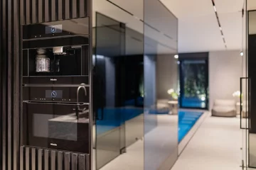 Vibe House w Krakowie – reinterpretacja strefy dziennej z basenem sąsiadującym z salonem i kuchnią 