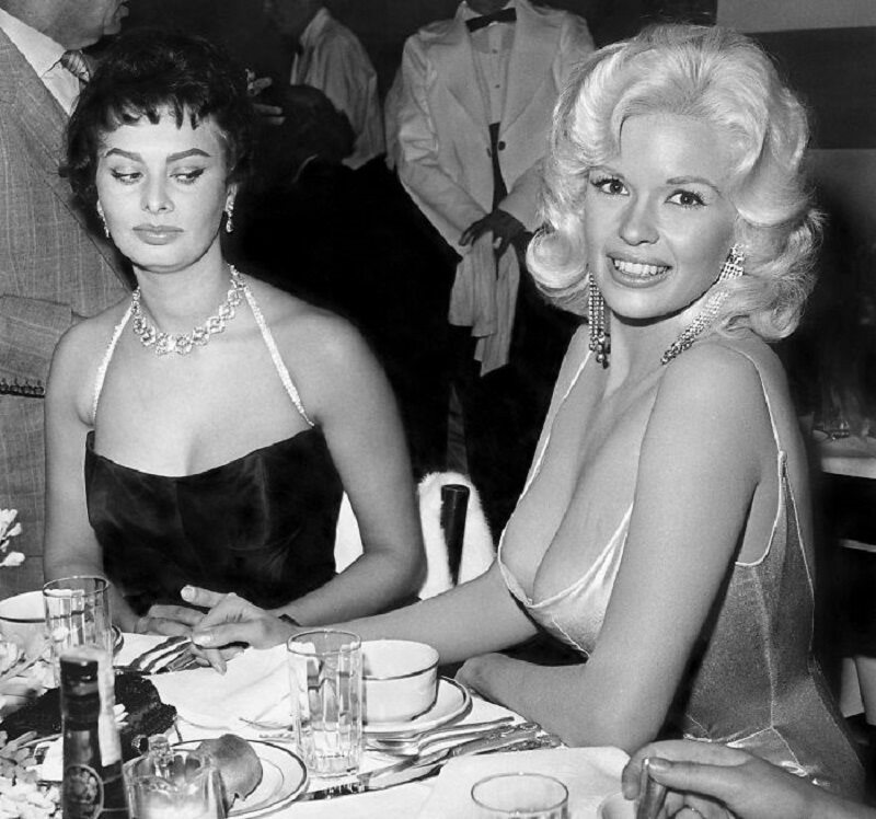 Sophia Loren i Jayne Mansfield podczas przyjęcia Sophia Loren wyjaśniła, co się naprawdę stało, gdy zrobiono to zdjęcie. Kiedy przysiadła się do niej Jayne Mansfield, Loren skupiła swój wzrok na jej biuście. - Obawiałam się, że zaraz znajdzie się on na moim talerzu - stwierdziła.